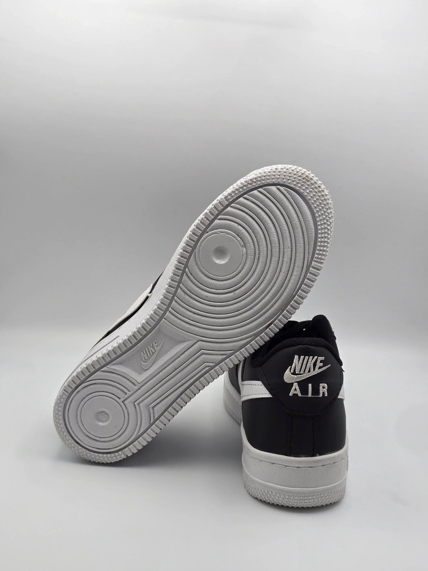 Schwarze und weiße Sneaker auf hellem Hintergrund, moderner Streetwear-Schuh, Produktfoto
