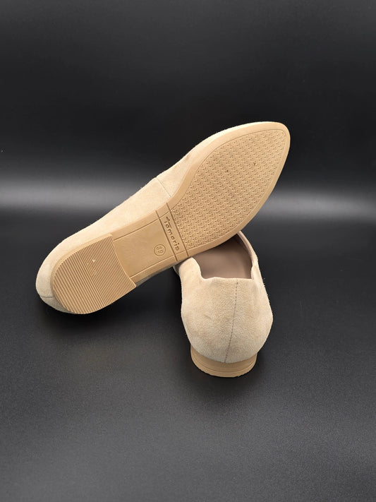 Beige Damen Slipper aus Wildleder mit flacher Sohle auf schwarzem Hintergrund, nachhaltige Mode