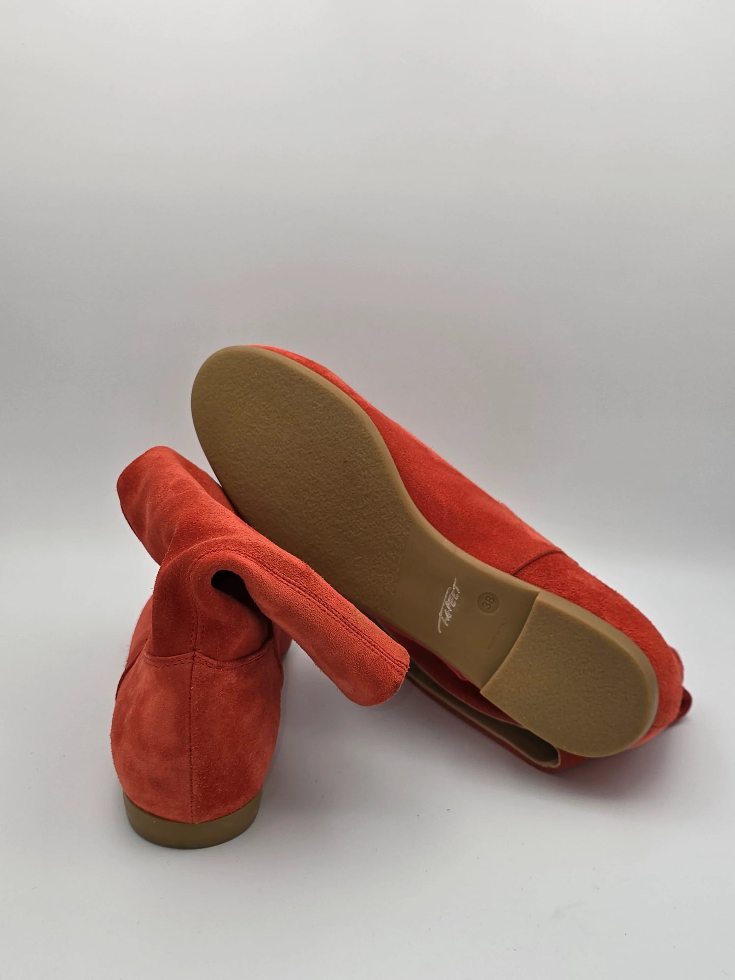 Rote Damenschuhe aus Wildleder mit flacher Sohle auf weißem Hintergrund, moderne Mode