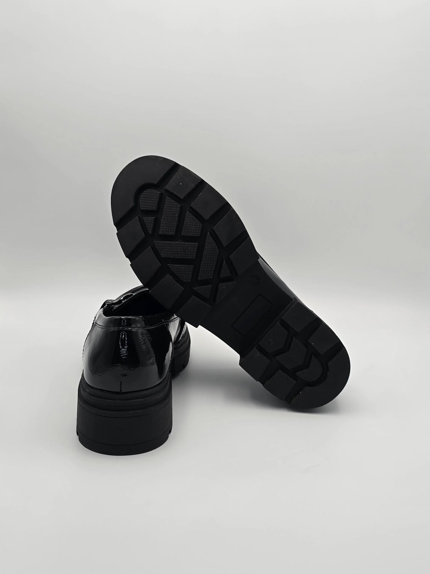 Schwarze Lackschuhe mit dicker Profilsohle, modern und modisch auf weißem Hintergrund