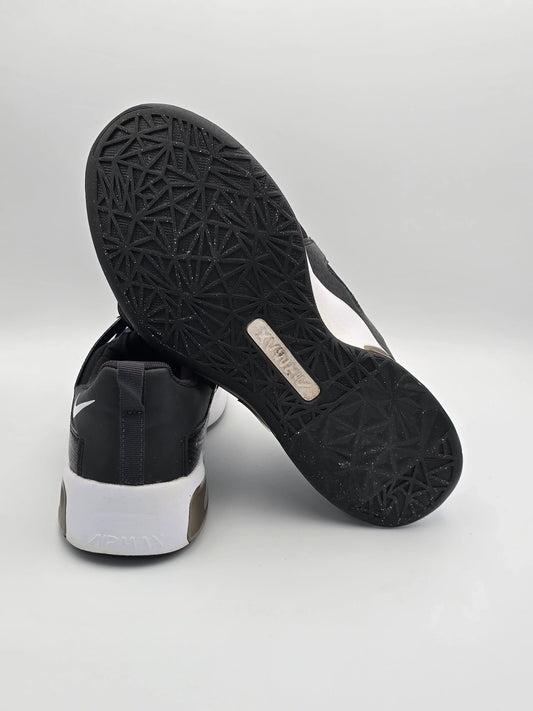 Schwarze Sneaker mit weißer Sohle und strukturiertem Profil auf hellem Hintergrund