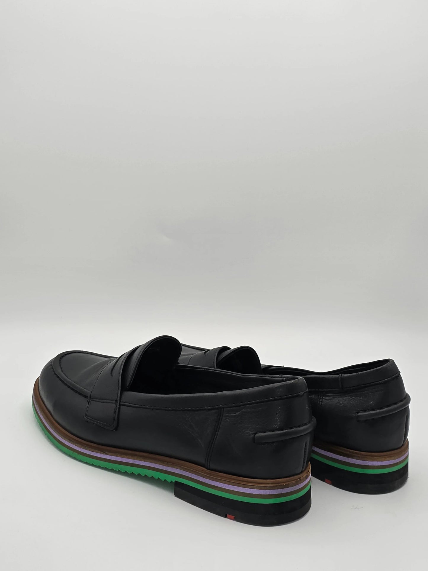Schwarze Loafer aus Leder mit bunter Sohle, nachhaltige Herrenschuhe auf weißem Hintergrund