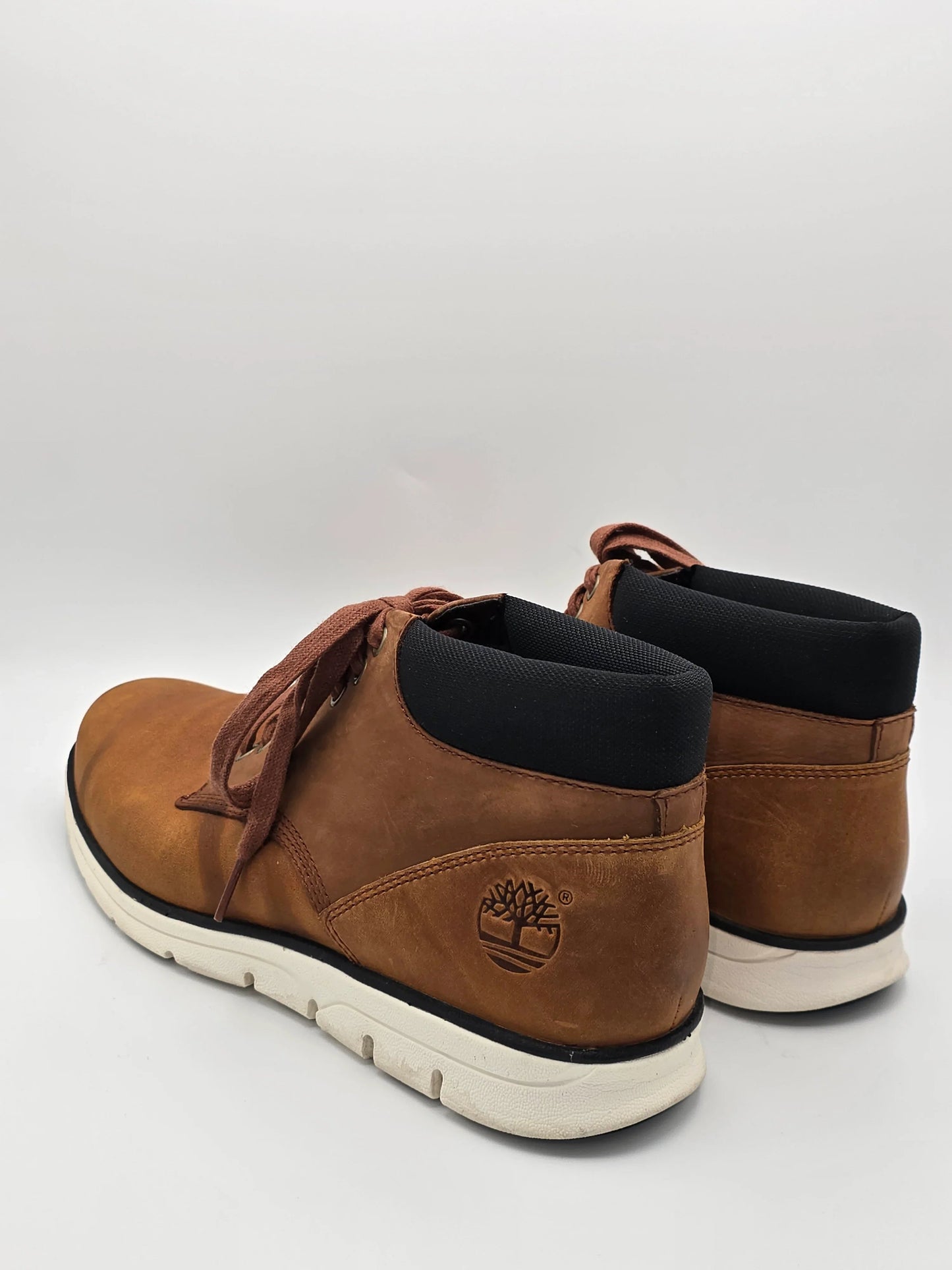Braune Leder-Sneaker für Herren mit weißer Sohle auf weißem Hintergrund, nachhaltige Mode