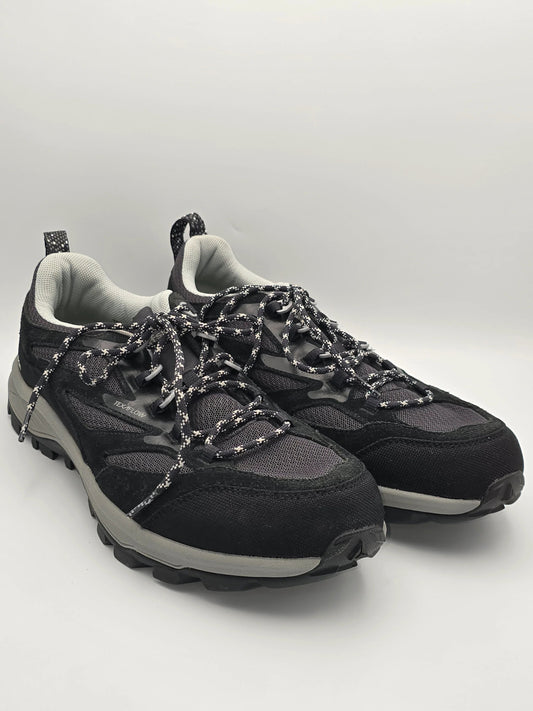 Schwarze Trekking-Sneaker mit dicker Sohle und gemusterten Schnürsenkeln auf weißem Hintergrund