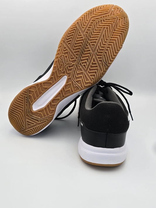 Schwarze Sneaker mit weißer Sohle und brauner Gummisohle, Sportschuhe auf weißem Hintergrund