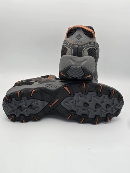 Graue Outdoor-Schuhe mit orangefarbenen Details und robuster Profilsohle auf weißem Hintergrund