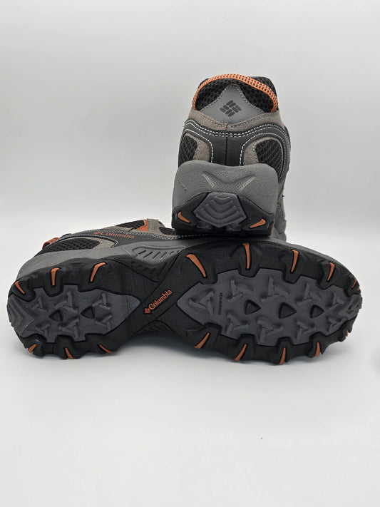 Graue Outdoor-Schuhe mit orangefarbenen Details und robuster Profilsohle auf weißem Hintergrund