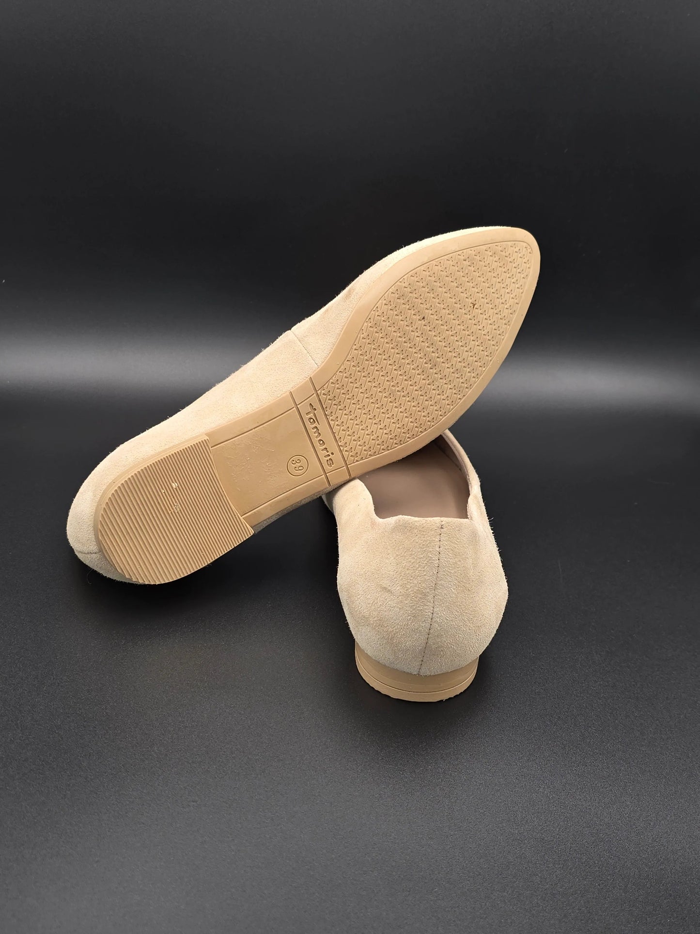 Beige Damen Slipper aus Wildleder mit flacher Sohle auf schwarzem Hintergrund, nachhaltige Mode