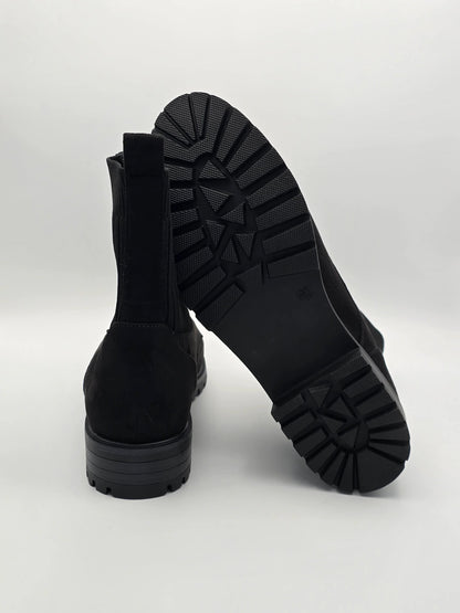 Schwarze Stiefeletten mit Profilsohle, nachhaltige Damen Schuhe auf weißem Hintergrund