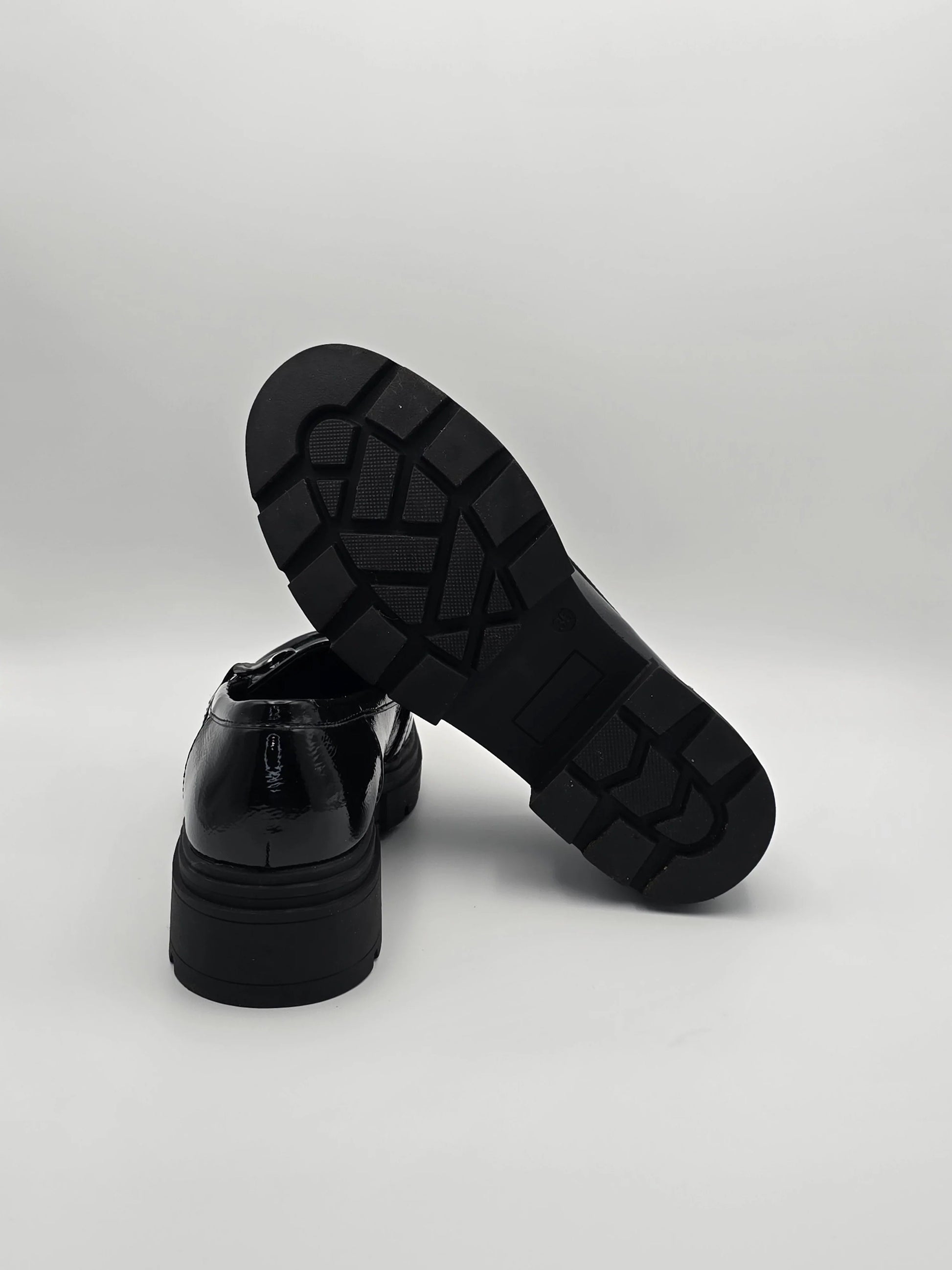 Schwarze Lackschuhe mit dicker Profilsohle, modern und modisch auf weißem Hintergrund