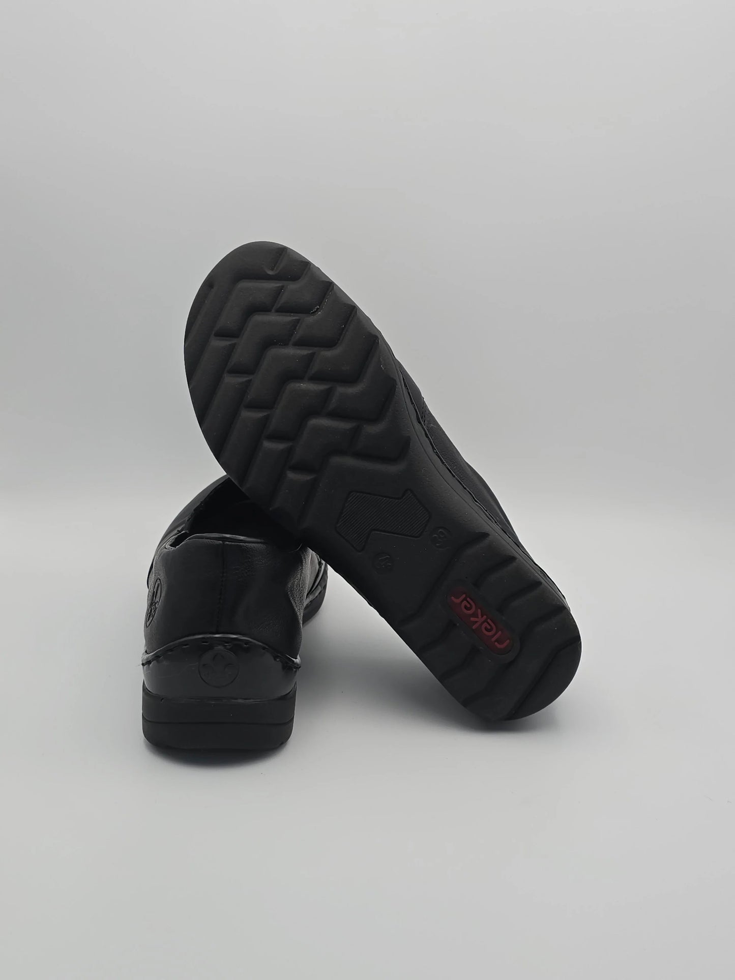 Schwarze Damen Slipper aus Leder mit rutschfester Sohle auf weißem Hintergrund