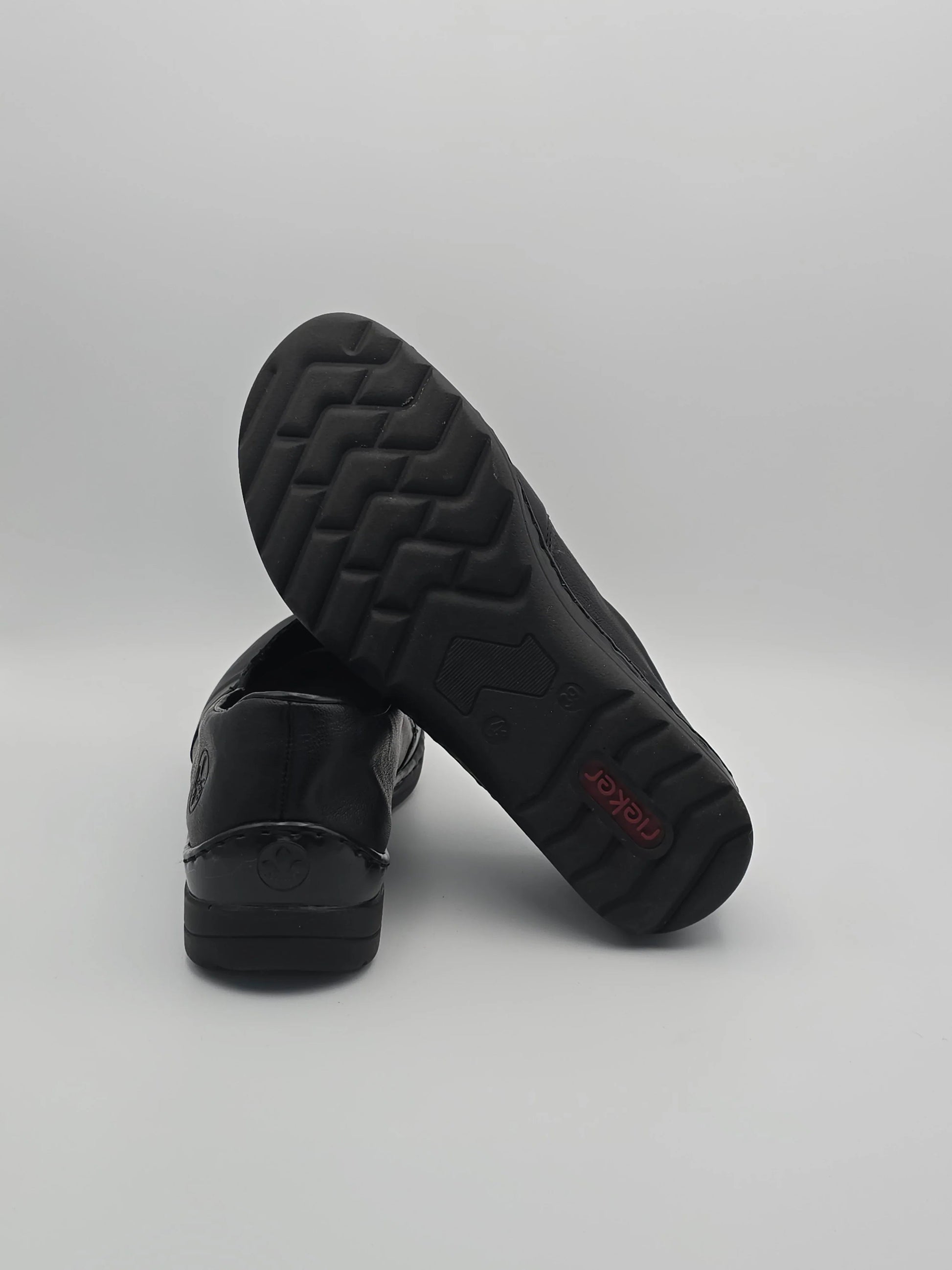Schwarze Damen Slipper aus Leder mit rutschfester Sohle auf weißem Hintergrund