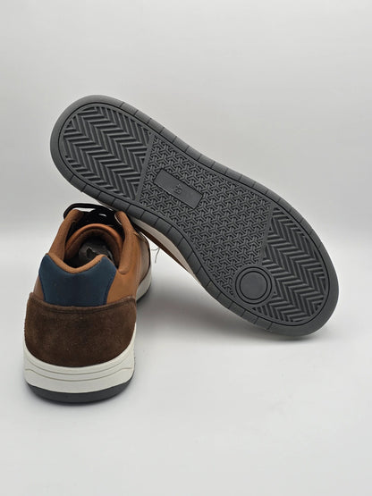 Brauner Sneaker aus Leder und Wildleder mit strukturierter Gummisohle auf weißem Hintergrund