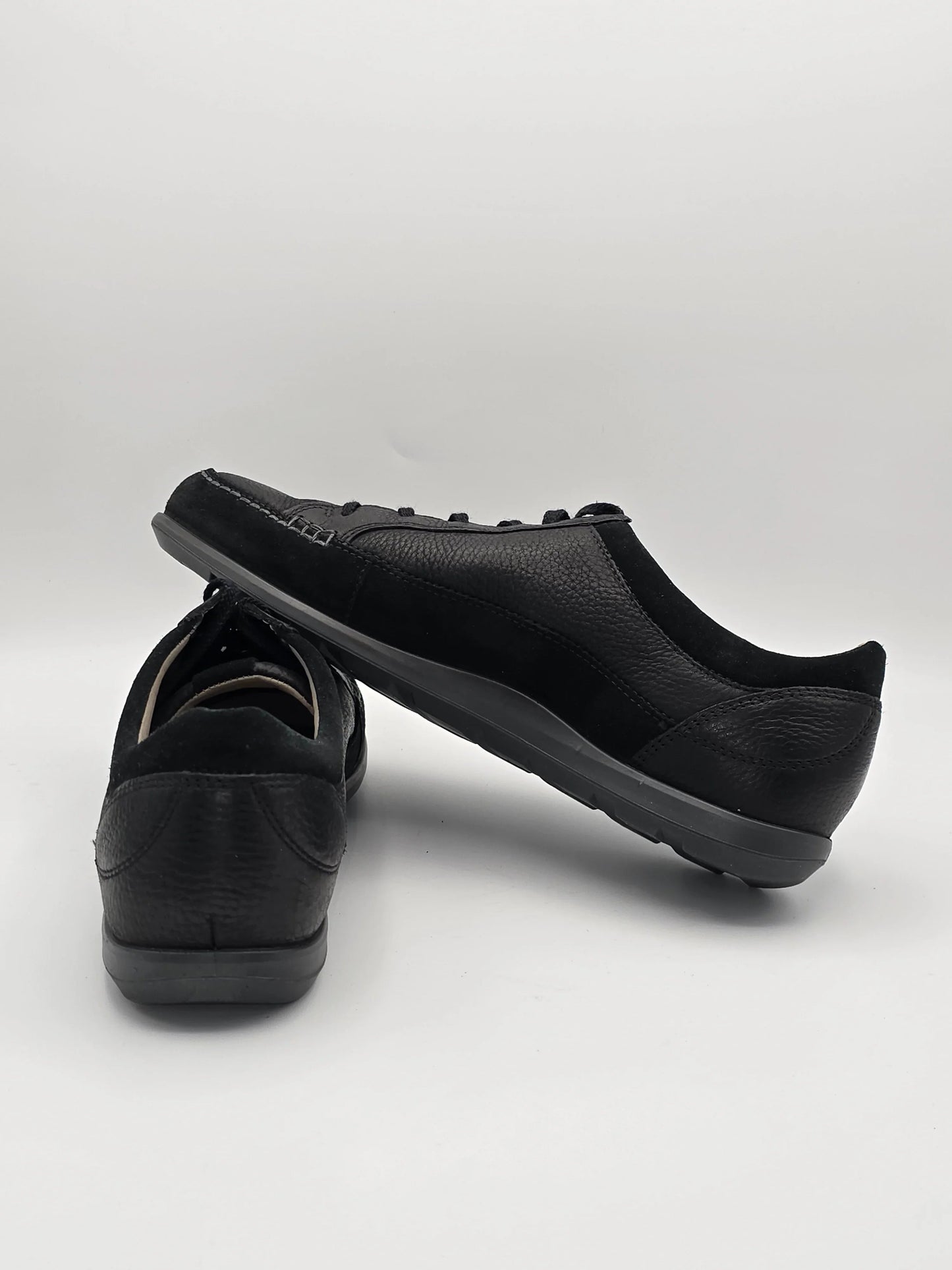 Schwarze Sneaker aus Leder, nachhaltige Mode, auf weißem Hintergrund präsentiert