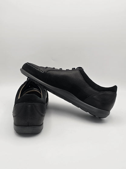 Schwarze Sneaker aus Leder, nachhaltige Mode, auf weißem Hintergrund präsentiert