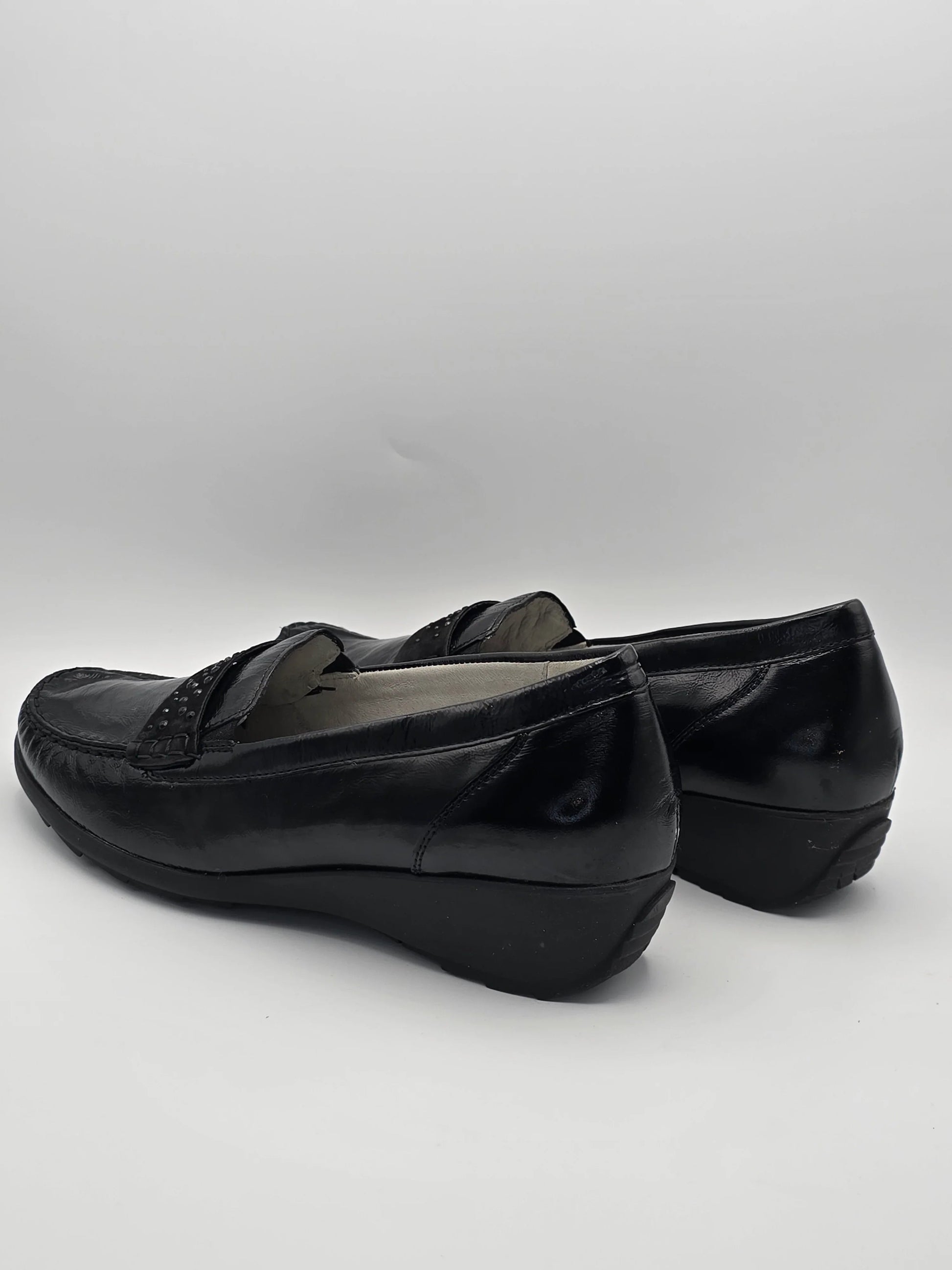 Schwarze Damen Slipper aus Leder mit Keilabsatz, modisch und bequem, vor weißem Hintergrund