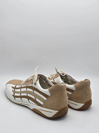 Beige und weiße Sneaker aus Leder und Wildleder mit Schnürsenkeln auf weißem Hintergrund