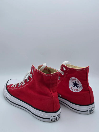 Rote High-Top Sneaker aus Canvas mit weißen Schnürsenkeln und Gummisohle auf weißem Hintergrund