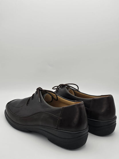 Dunkle Lederschuhe für Damen mit Schnürung, nachhaltige Mode auf weißem Hintergrund