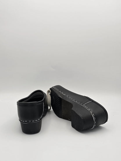 Schwarze Lederschuhe mit dicker Sohle und weißer Ziernaht, Mode Schuhe auf weißem Hintergrund