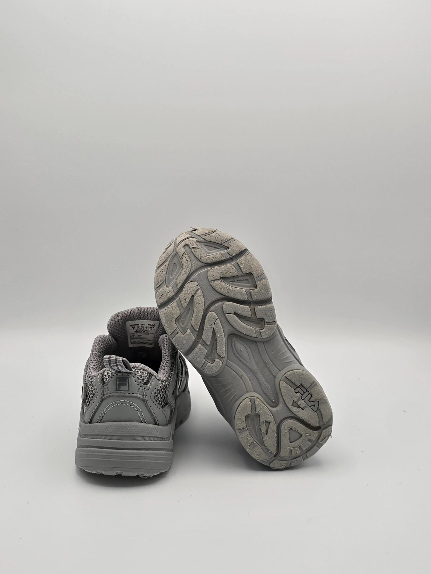 Grau Sneaker Paar aus Mesh und Kunstleder, Rück- und Sohlenansicht auf weißem Hintergrund