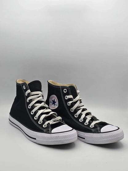 Schwarze High-Top-Sneaker aus Canvas mit weißer Sohle und Schnürsenkeln auf hellem Hintergrund