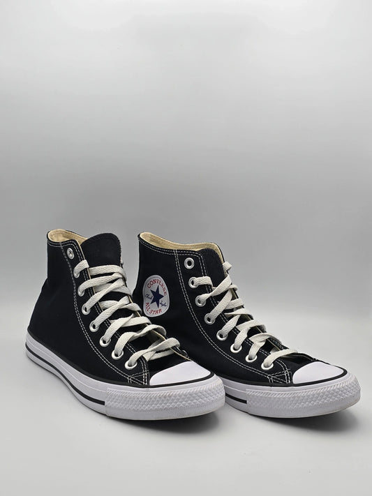 Schwarze High-Top-Sneaker aus Canvas mit weißer Sohle und Schnürsenkeln auf hellem Hintergrund