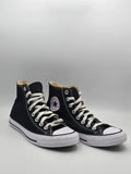 Schwarze High-Top-Sneaker aus Canvas mit weißer Sohle und Schnürsenkeln auf hellem Hintergrund