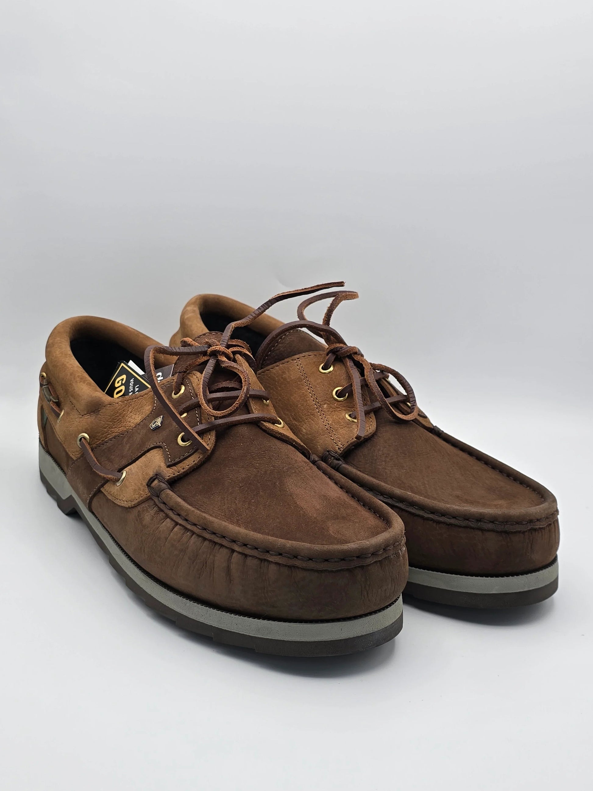 Braune Herren Bootsschuhe aus Leder mit Schnürsenkeln, modisch und robust, auf weißem Hintergrund.