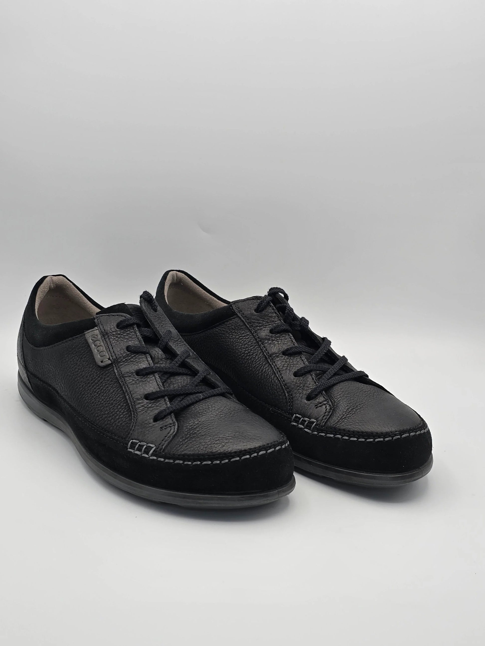 Schwarze Herrenschuhe aus Leder mit Schnürung, modern und elegant, auf weißem Hintergrund