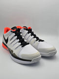 Weiße Sneaker mit schwarzem Logo, orangen Akzenten und sportlichem Design auf hellem Hintergrund.
