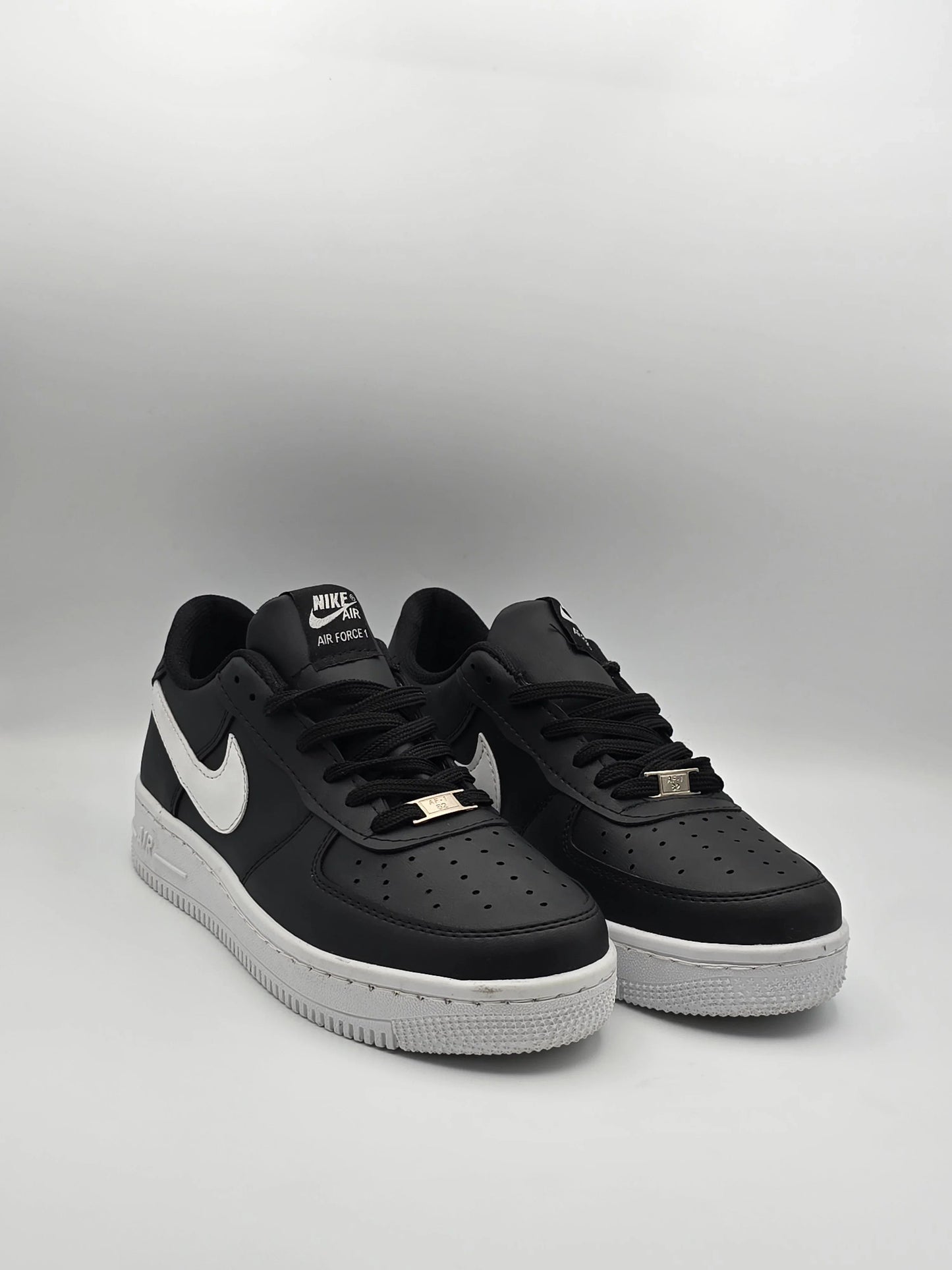 Schwarze Sneaker mit weißer Sohle und weißem Logo, moderne Herrenschuhe auf hellem Hintergrund.