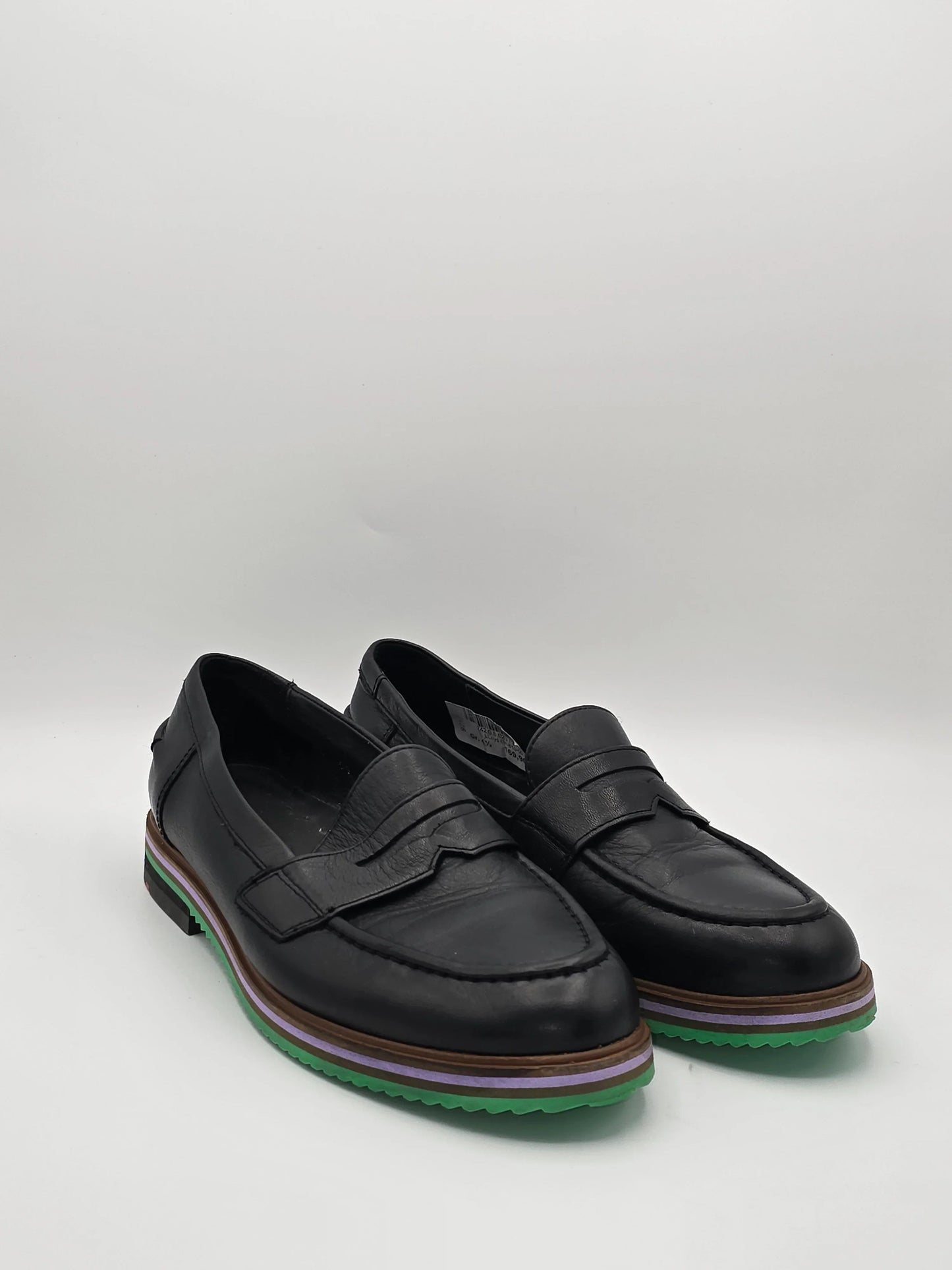 Schwarze Leder Slipper mit grün-lila Sohle, modische Damen Schuhe auf weißem Hintergrund