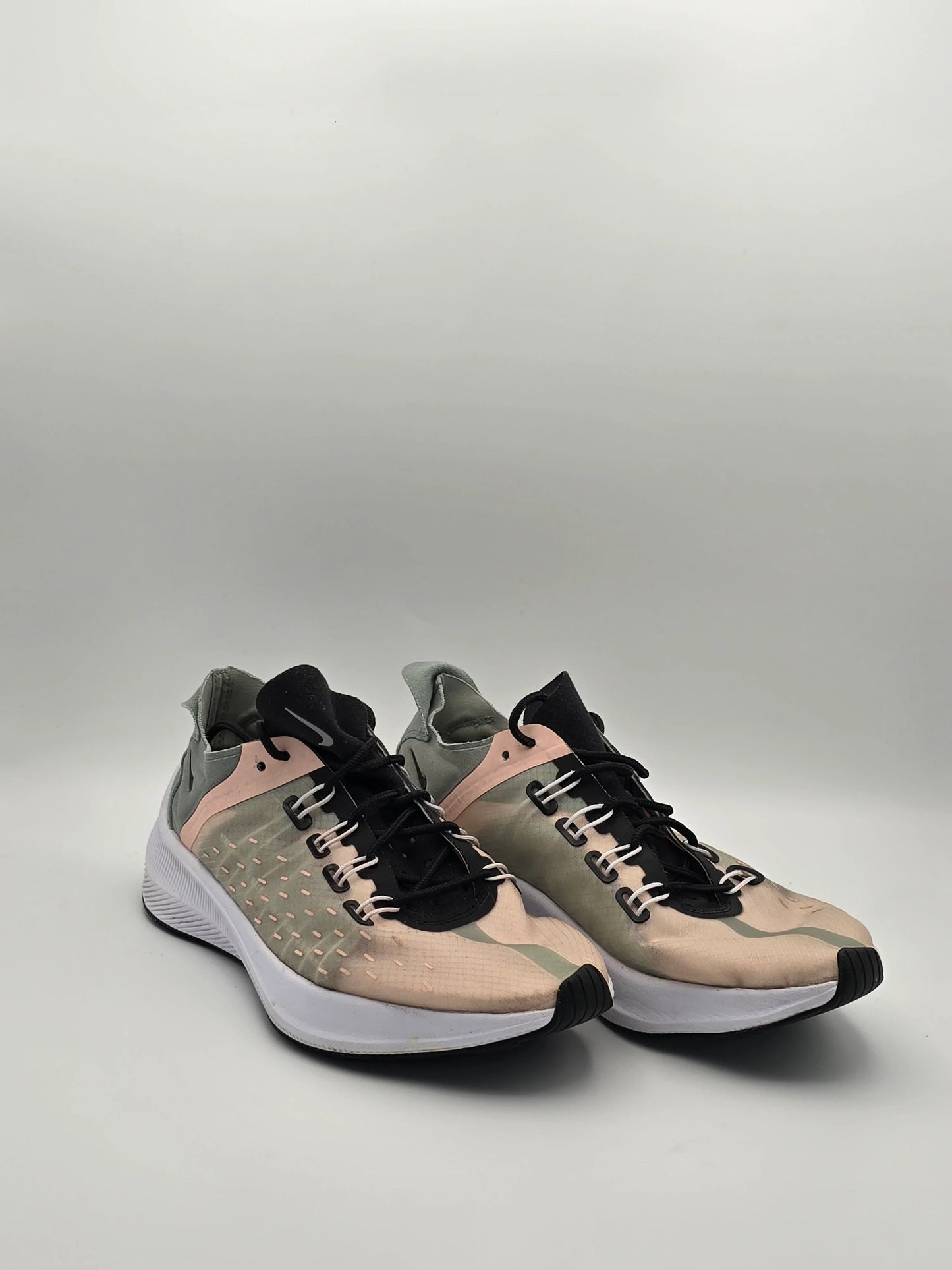 Beige grüne Sneaker mit schwarzer Zunge und weißer Sohle auf neutralem Hintergrund
