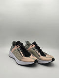 Beige grüne Sneaker mit schwarzer Zunge und weißer Sohle auf neutralem Hintergrund