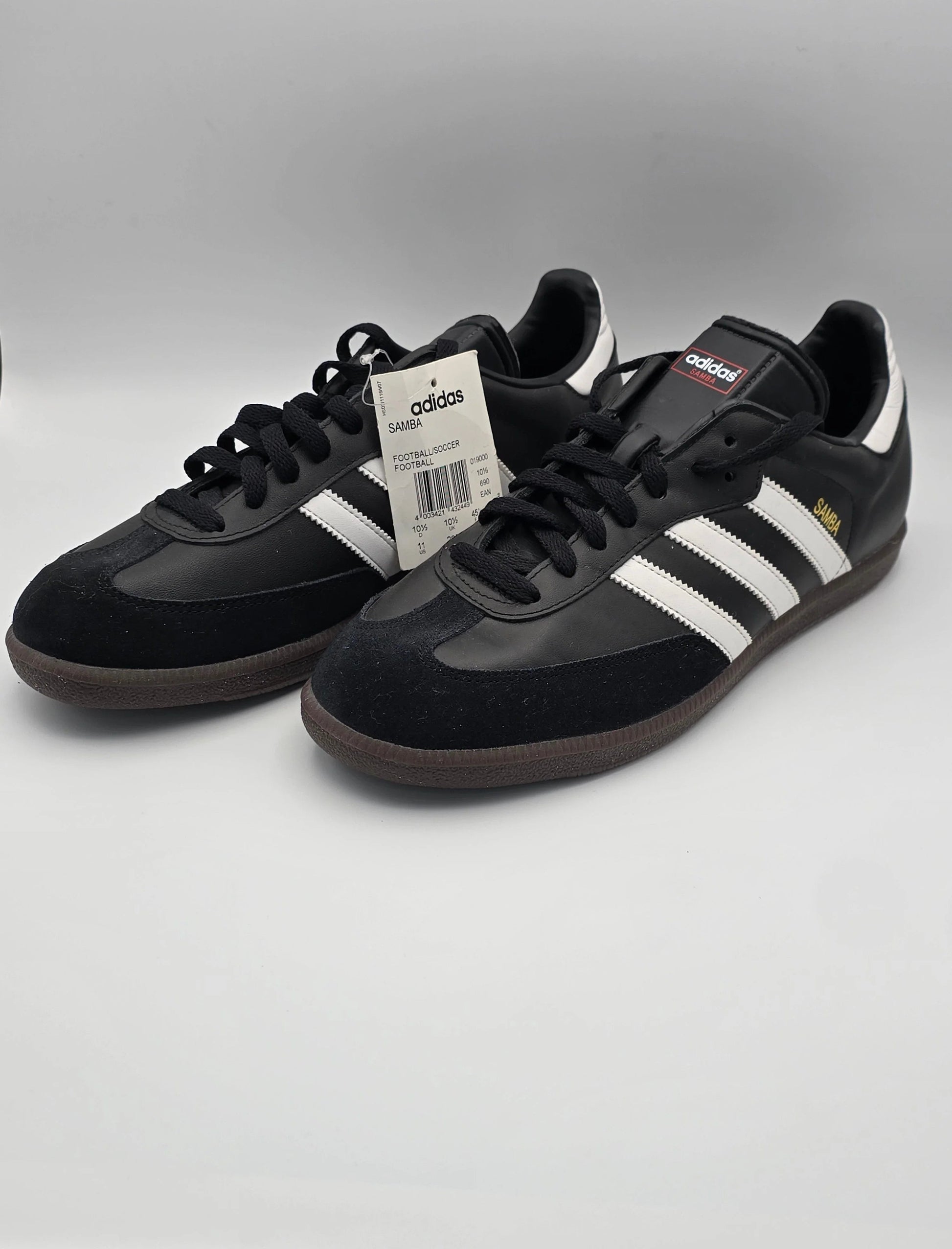 Schwarze Sneakers mit weißen Streifen, klassische Adidas Samba Schuhe auf weißem Hintergrund.
