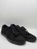 Schwarze Sneaker mit schwarzen Schnürsenkeln und roten Akzenten, modische Herrenschuhe