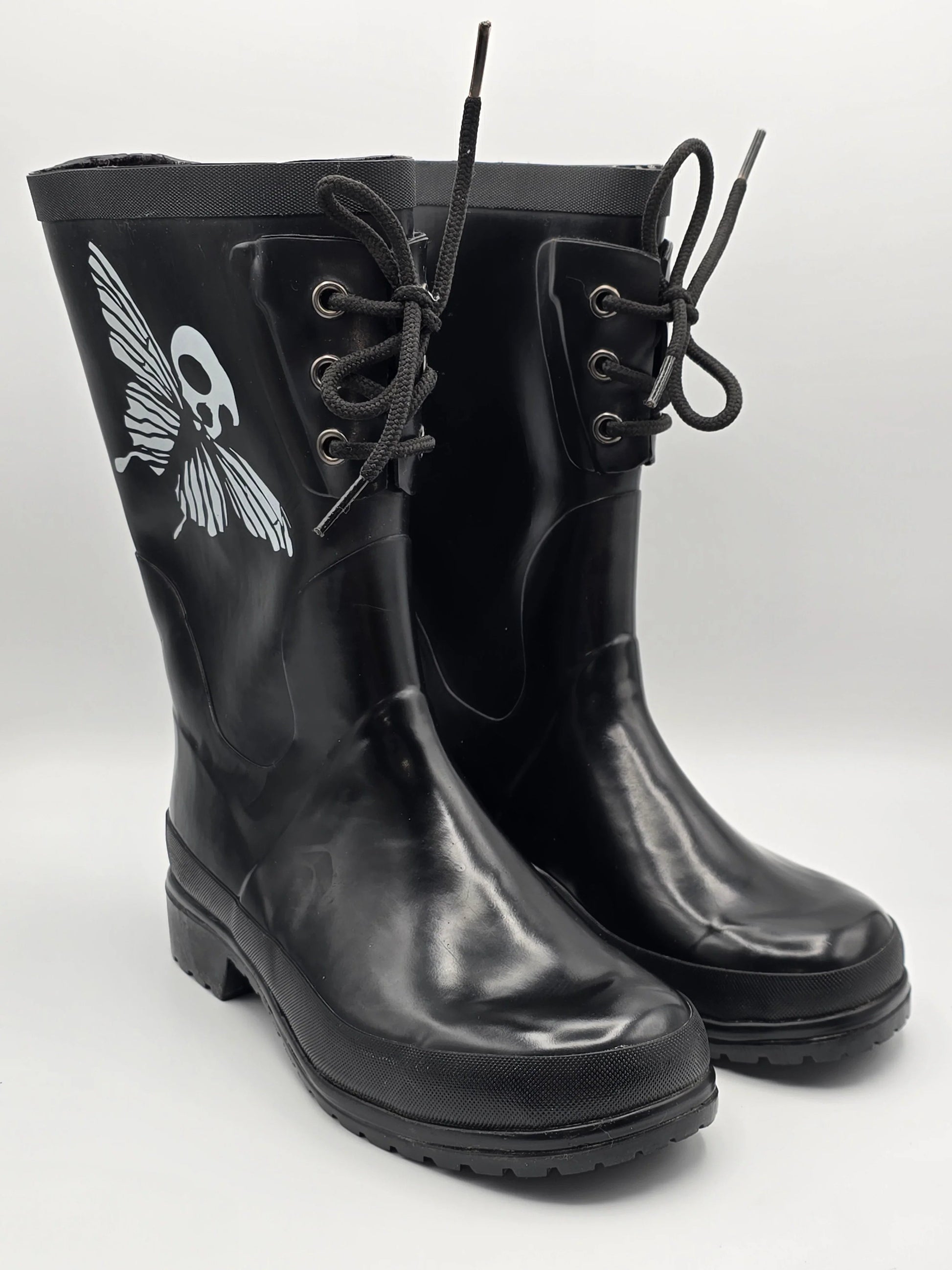 Schwarze Gummistiefel mit Schnürsenkeln und weißem Totenkopf-Schmetterling Motiv