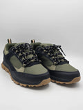 Grüne und schwarze Sneaker mit Profilsohle und gemusterten Schnürsenkeln vor weißem Hintergrund